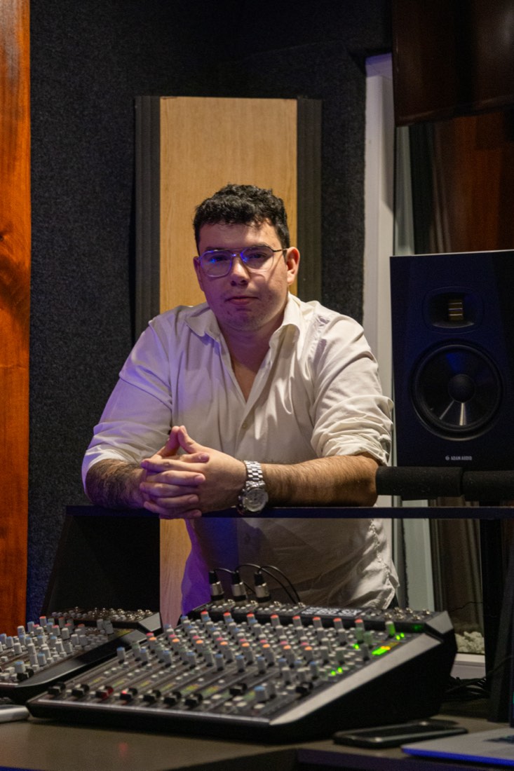 Juan Carlos Deras en su estudio, apoyado sobre la consola