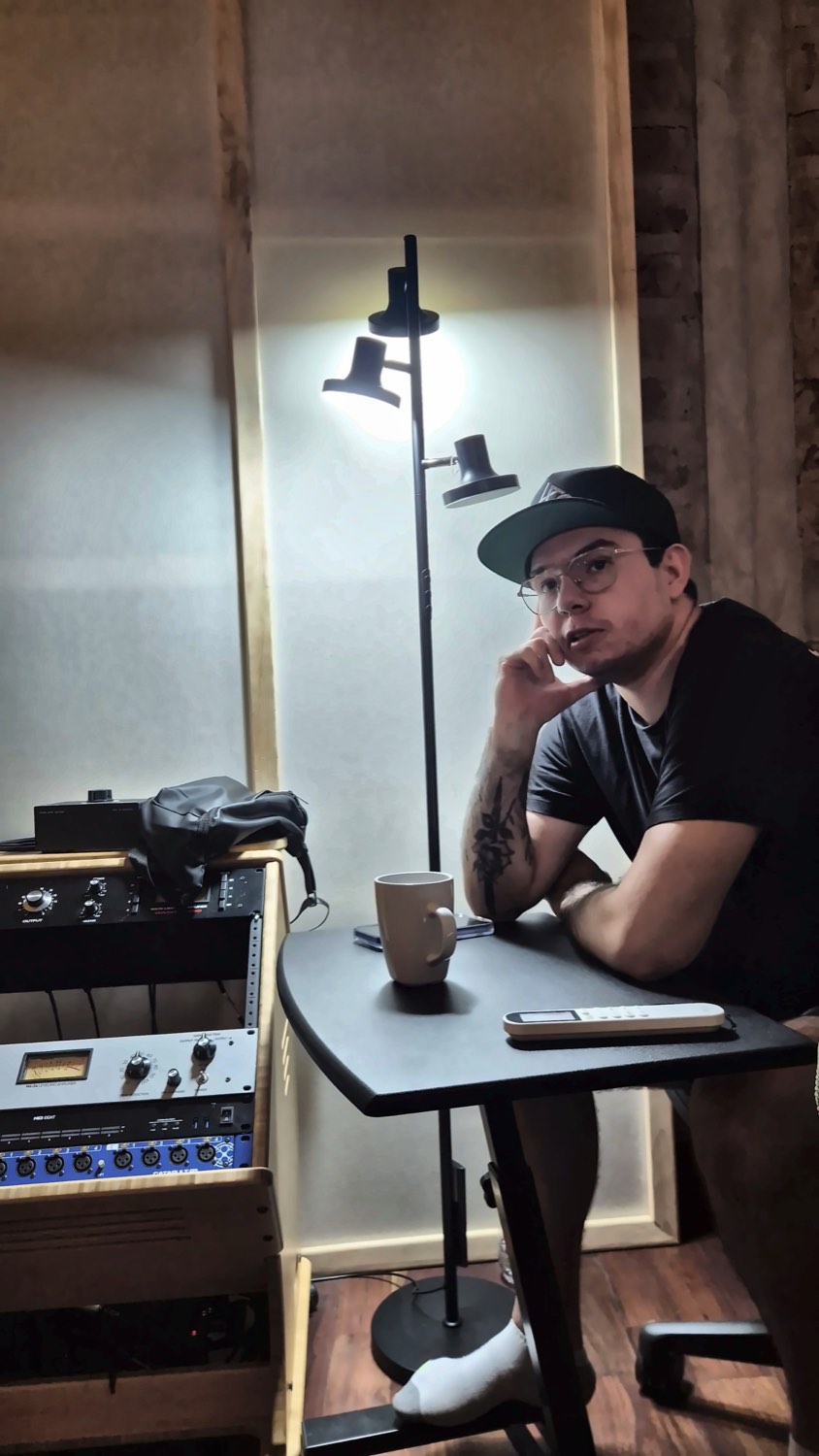 Juan Carlos Deras sentado en el estudio, junto a su rack de equipo analógico